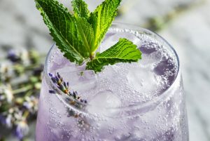 a drink with a mint leaf and lavendar