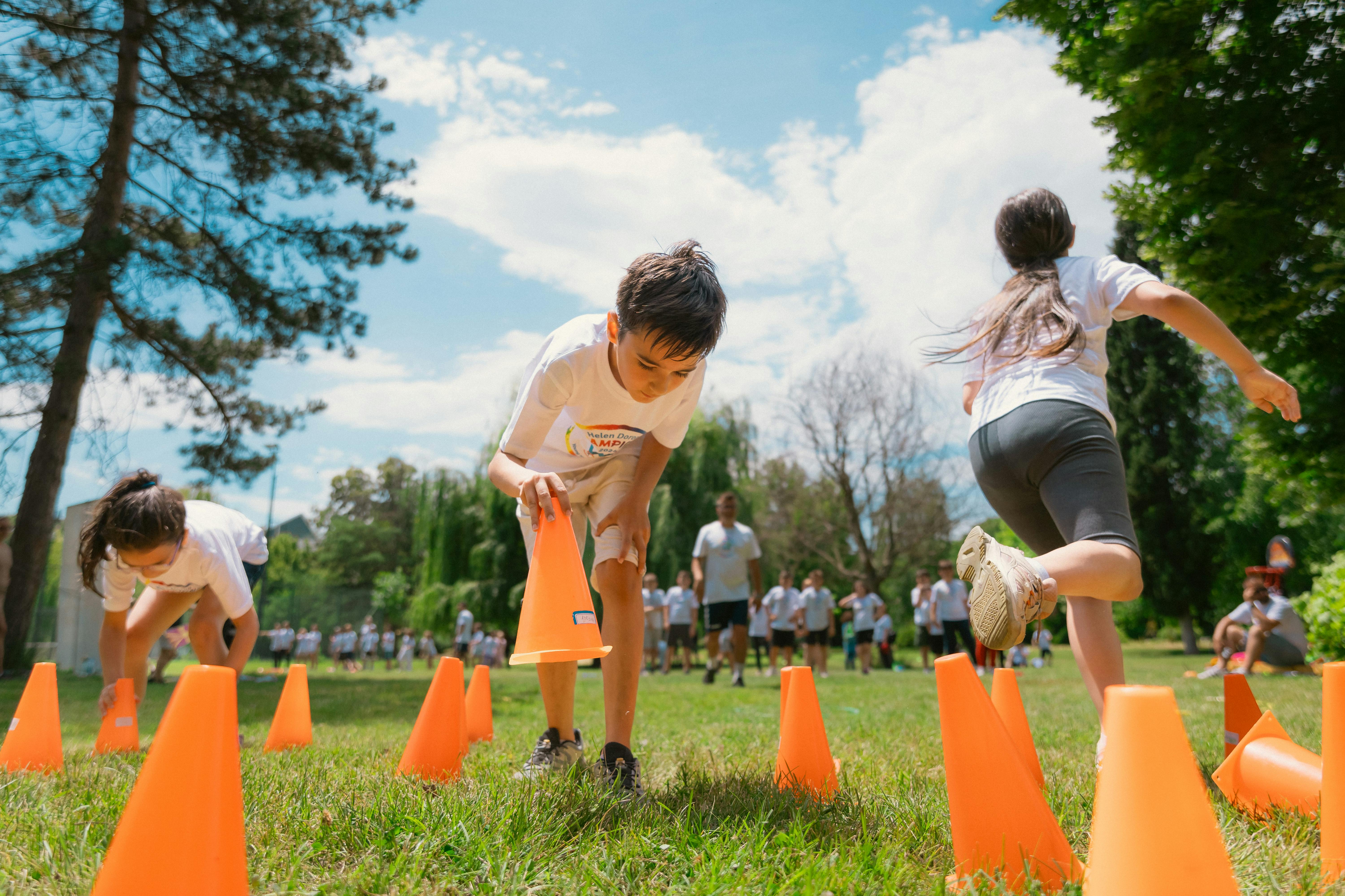 kids playing in an obstacle course with orange cones