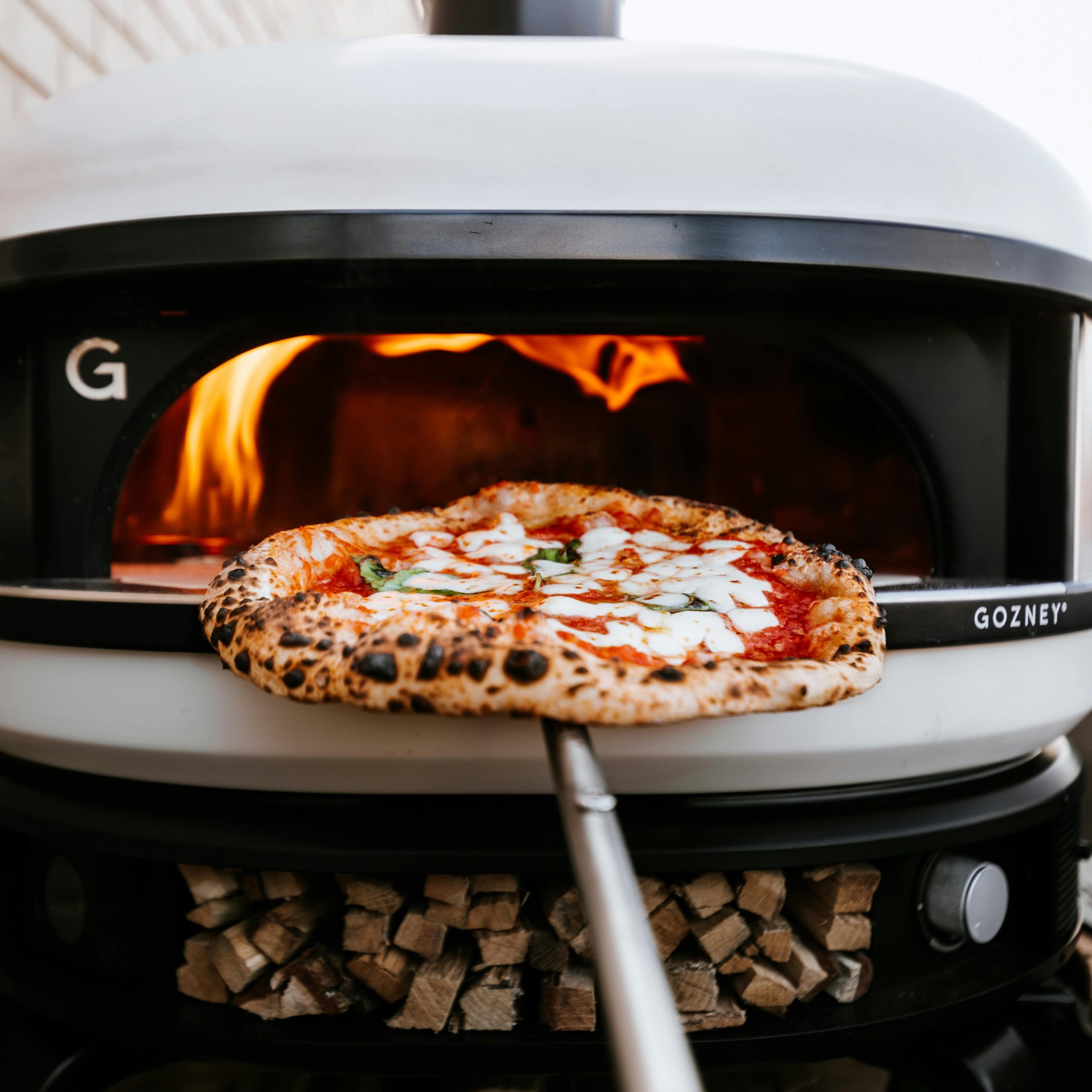 Freshly baked Neapolitan pizza in a wood-fired oven in London. Perfectly charred crust.