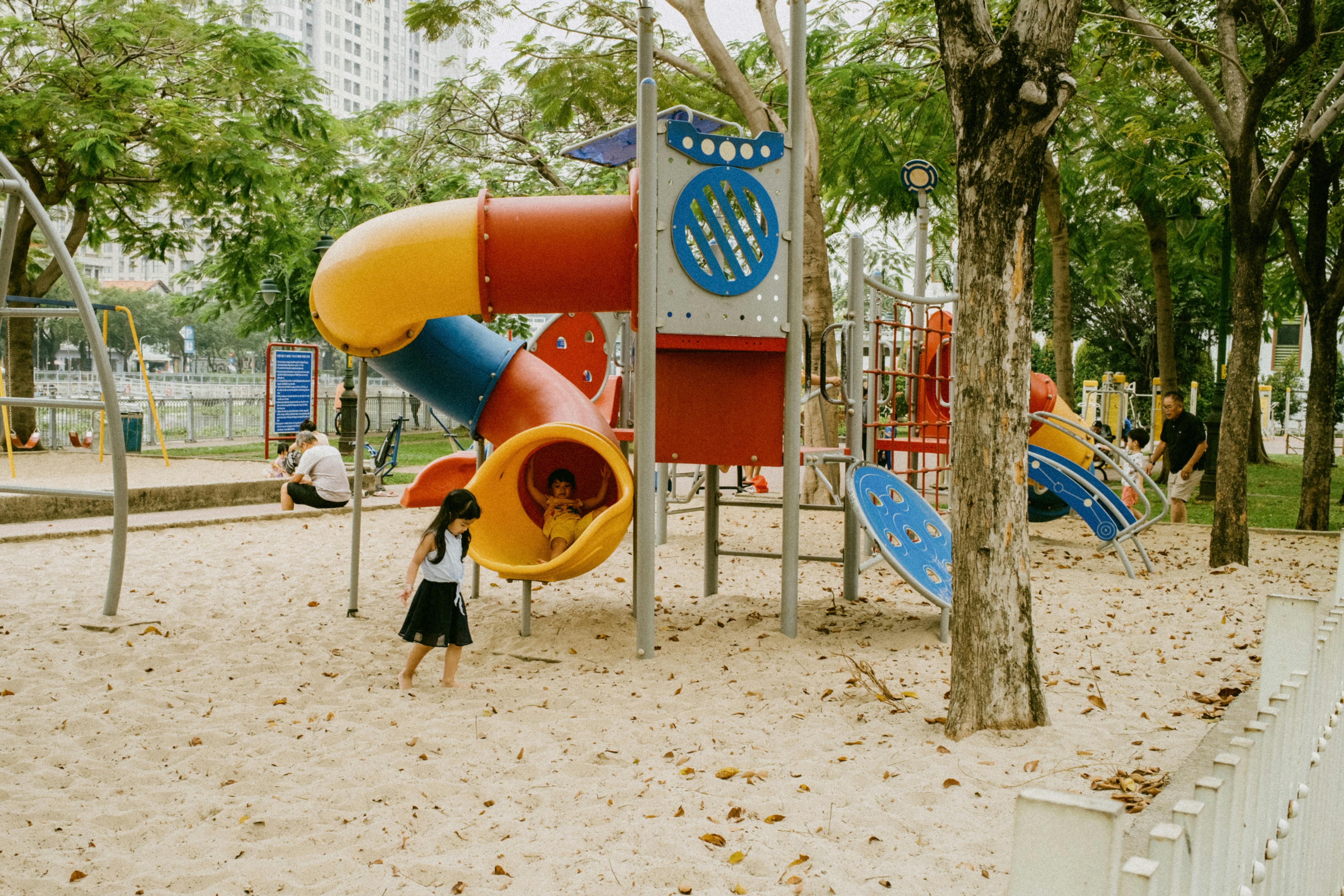 a colorful playground for kids with a sand base