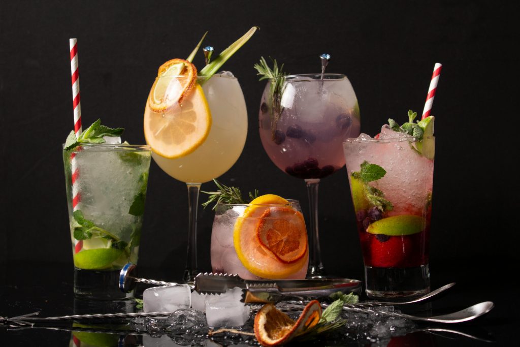 A diverse collection of colorful cocktails with garnishes, perfect for a refreshing drink experience.