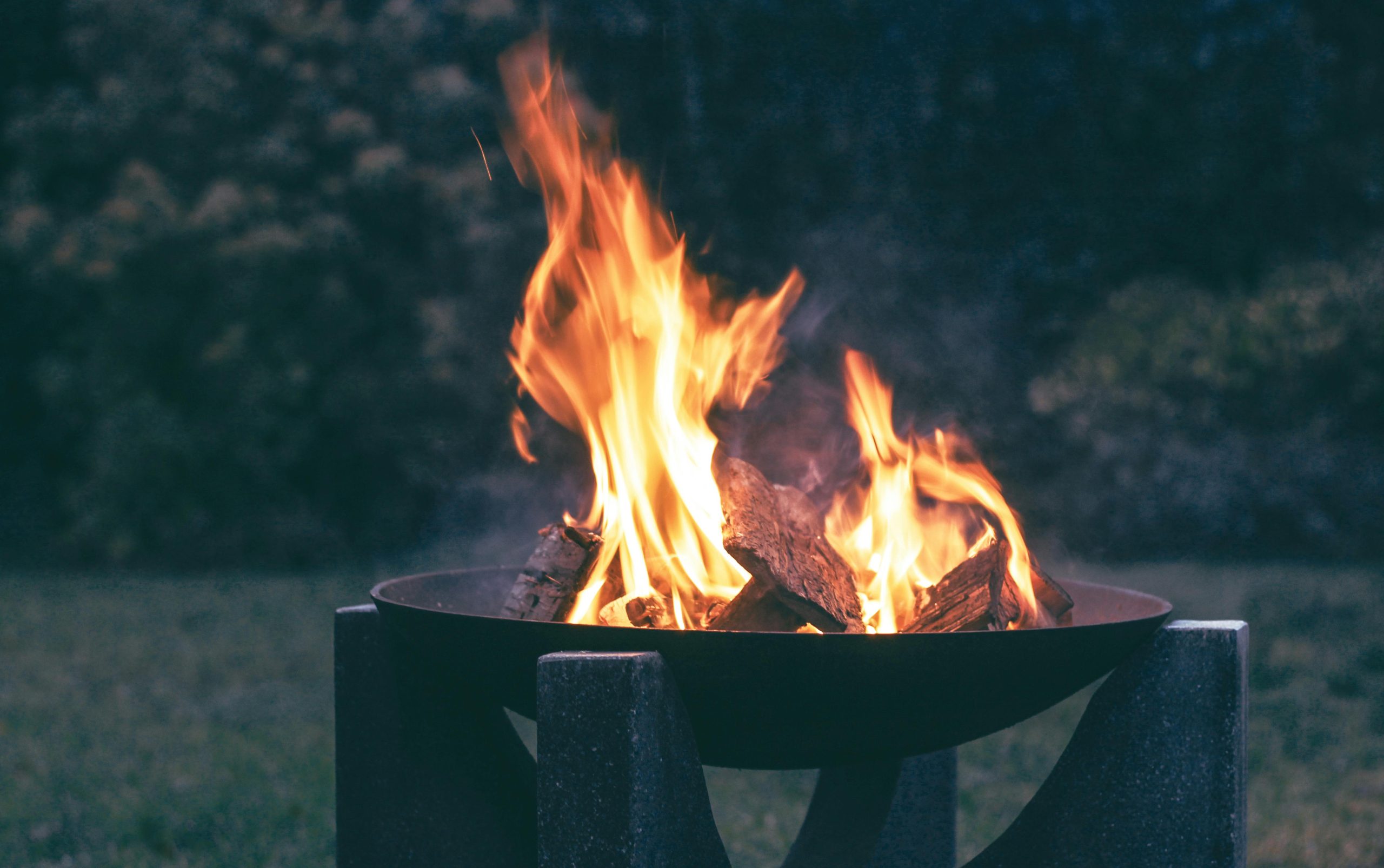 A close-up of a warm and inviting campfire in an outdoor fire pit during the evening.